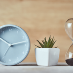 A clock and hourglass depicting the need for time management in order to avoid Medicare late enrollment penalties