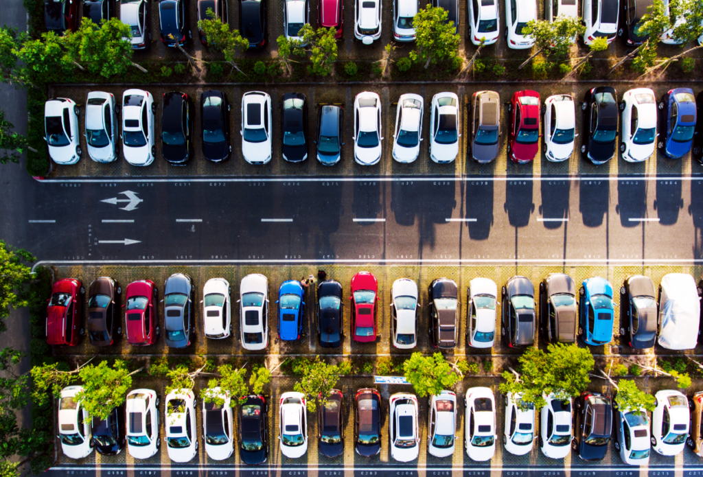 Aerial view of parked cars, representing various types of car insurance needs, including liability, collision, and comprehensive coverage.