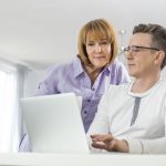 Husband and wife who are turning 65 researching Medicare on their computer
