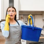 Upset homeowner calling plumber due to leakage in kitchen.