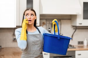 Upset homeowner calling plumber due to leakage in kitchen.