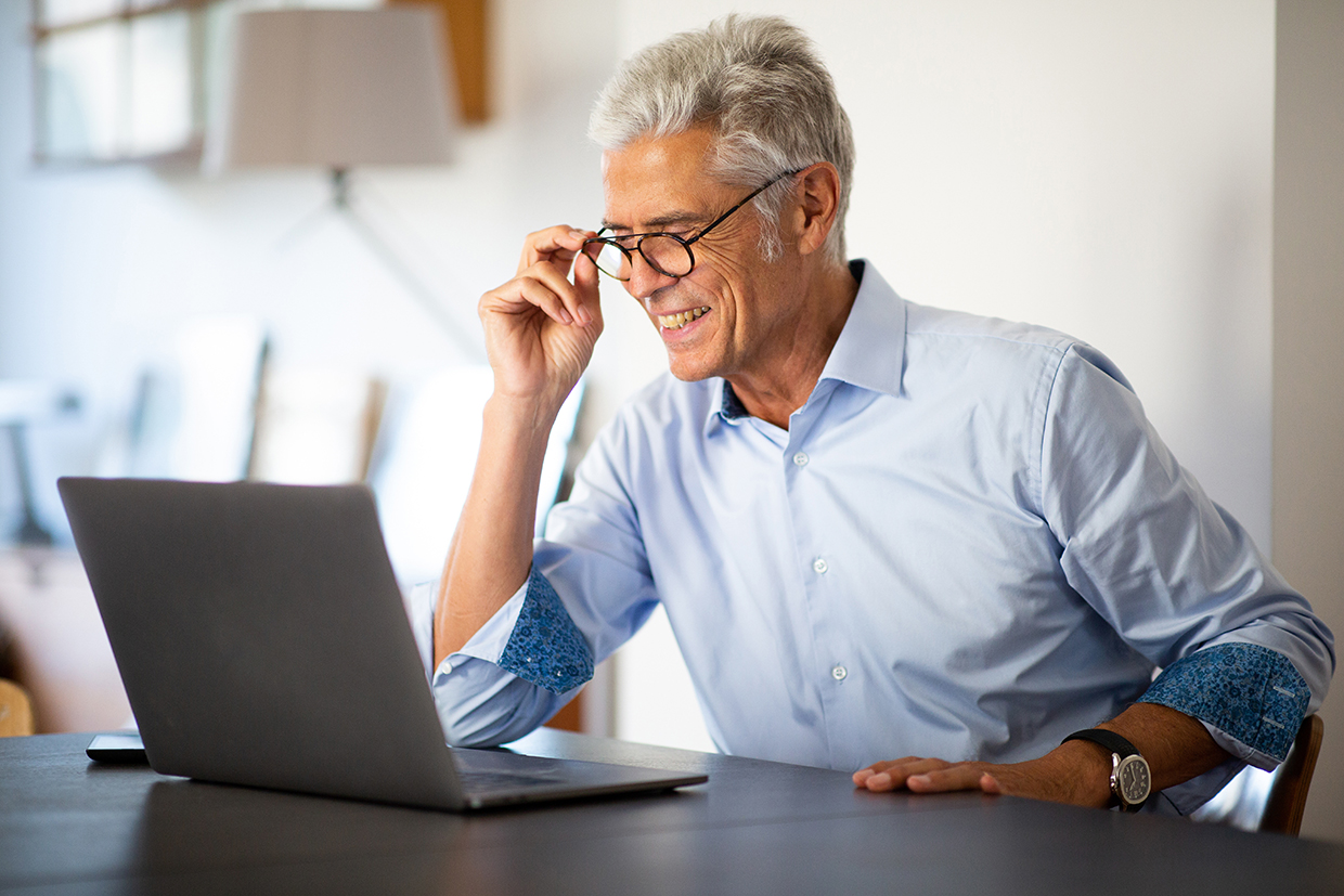 Senior man with glasses looking at laptop researching Medicare Part A