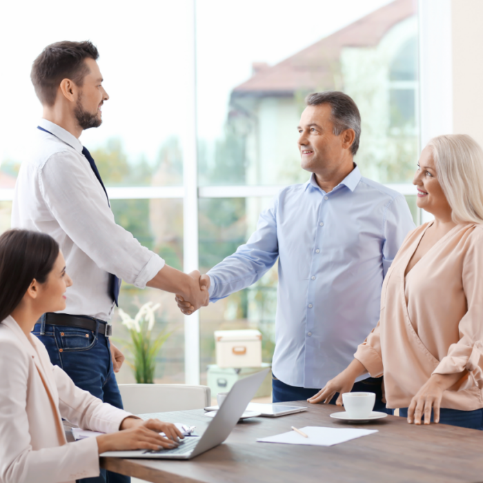 Couple shaking hands with insurance agent after discussing retirement and life insurance.