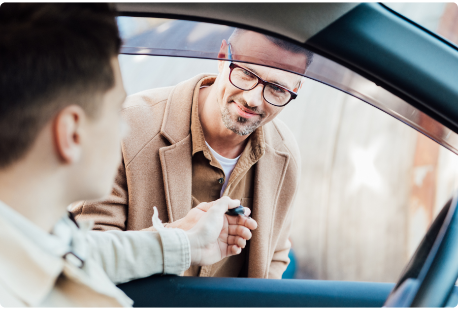 Cheerful father giving-car keys to teenage son