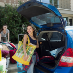 College students unpacking a car to move into their dorm