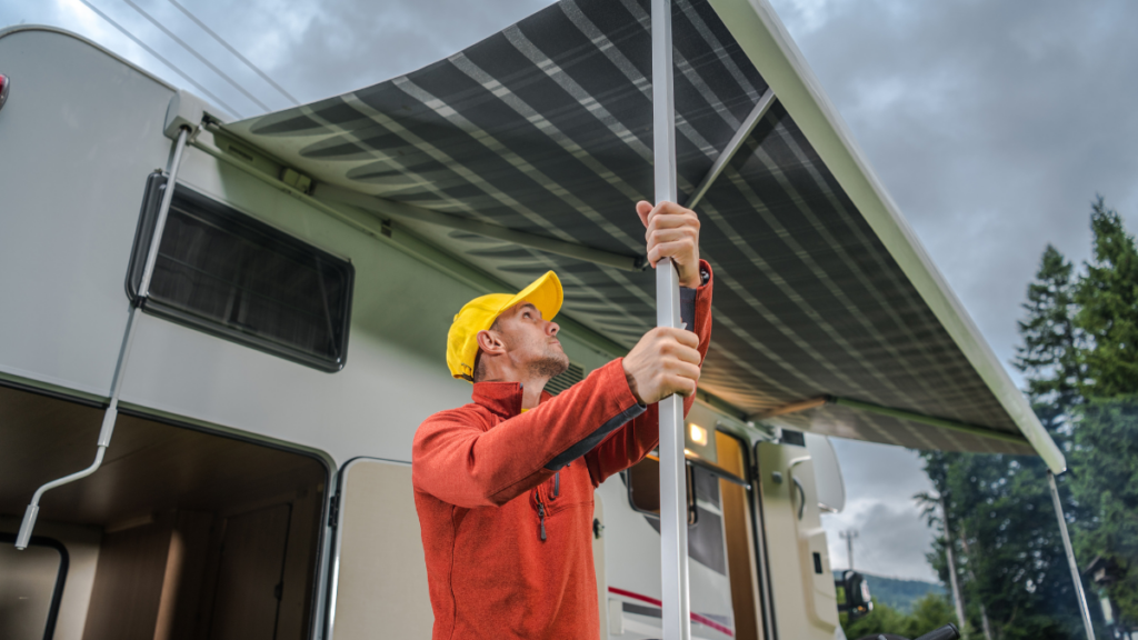 RV owner prepping for rain by putting up awning